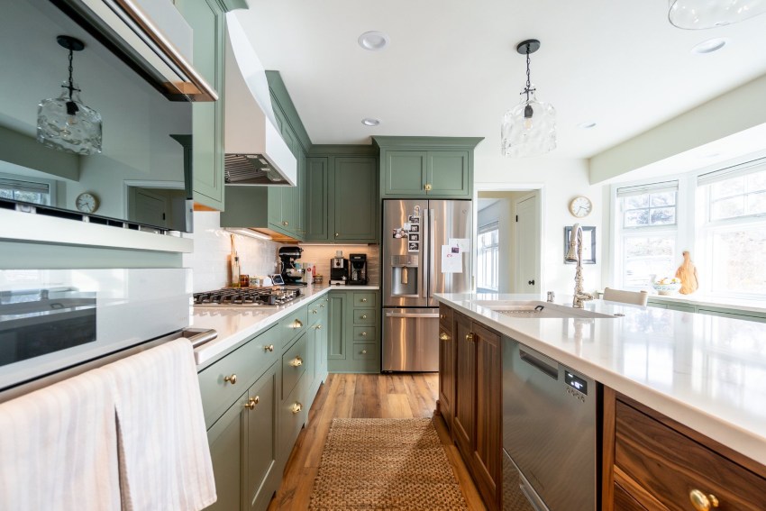 A kitchen with green cabinets & wood floors showcasing remodeling design in the Milwaukee Metro Area