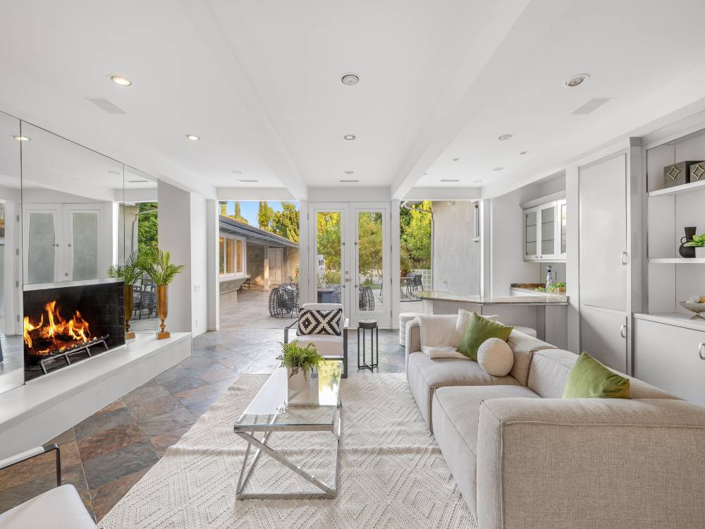 Spacious living room featuring built in shelves, fireplace, and large windows